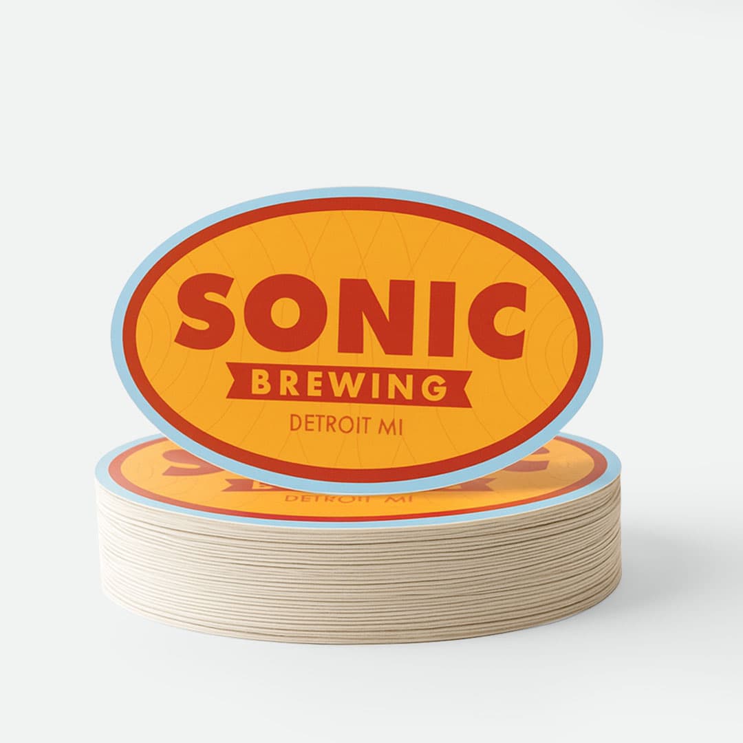 Stack of custom oval die cut stickers with a brewery logo showing vibrant full color printing and clean precision cuts.