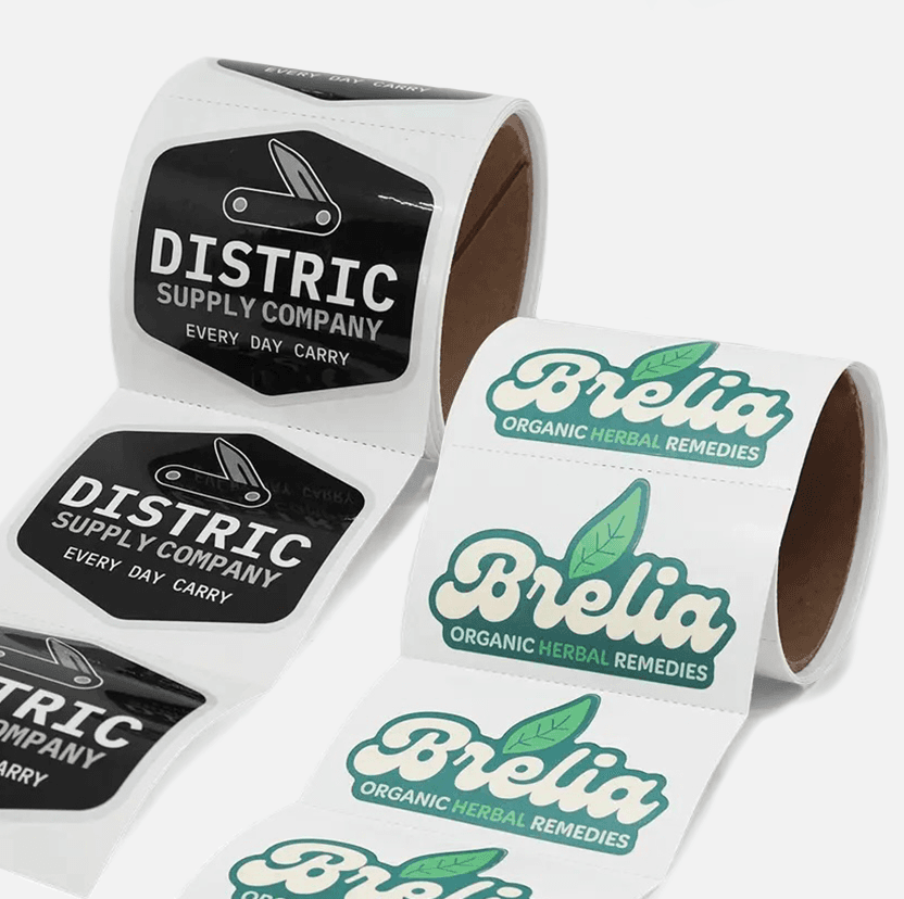 Custom kiss cut sticker rolls with perforations featuring logo designs for branding, promotions, and product packaging.