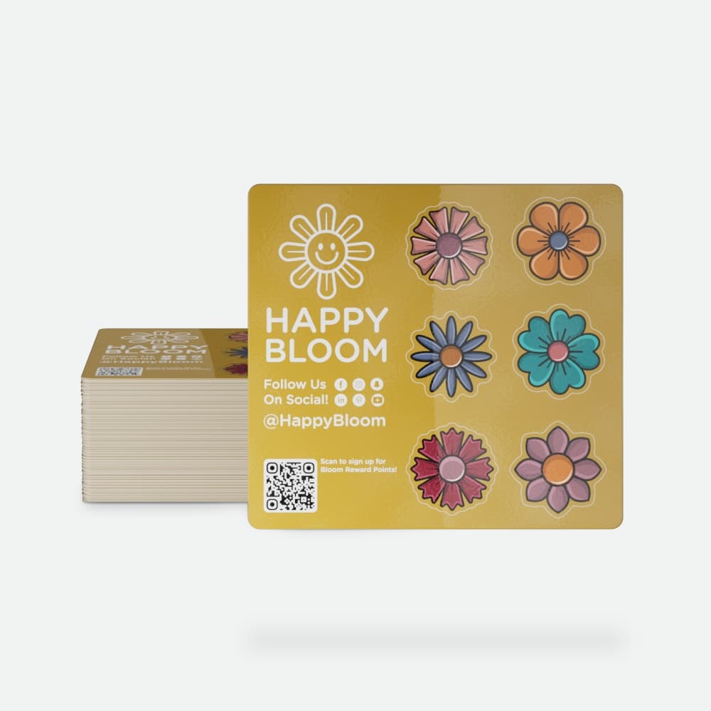 A “Happy Bloom” sticker sheet with colorful flower designs, social media icons, and a QR code appears in front of a stack of matching sheets on a light gray background.