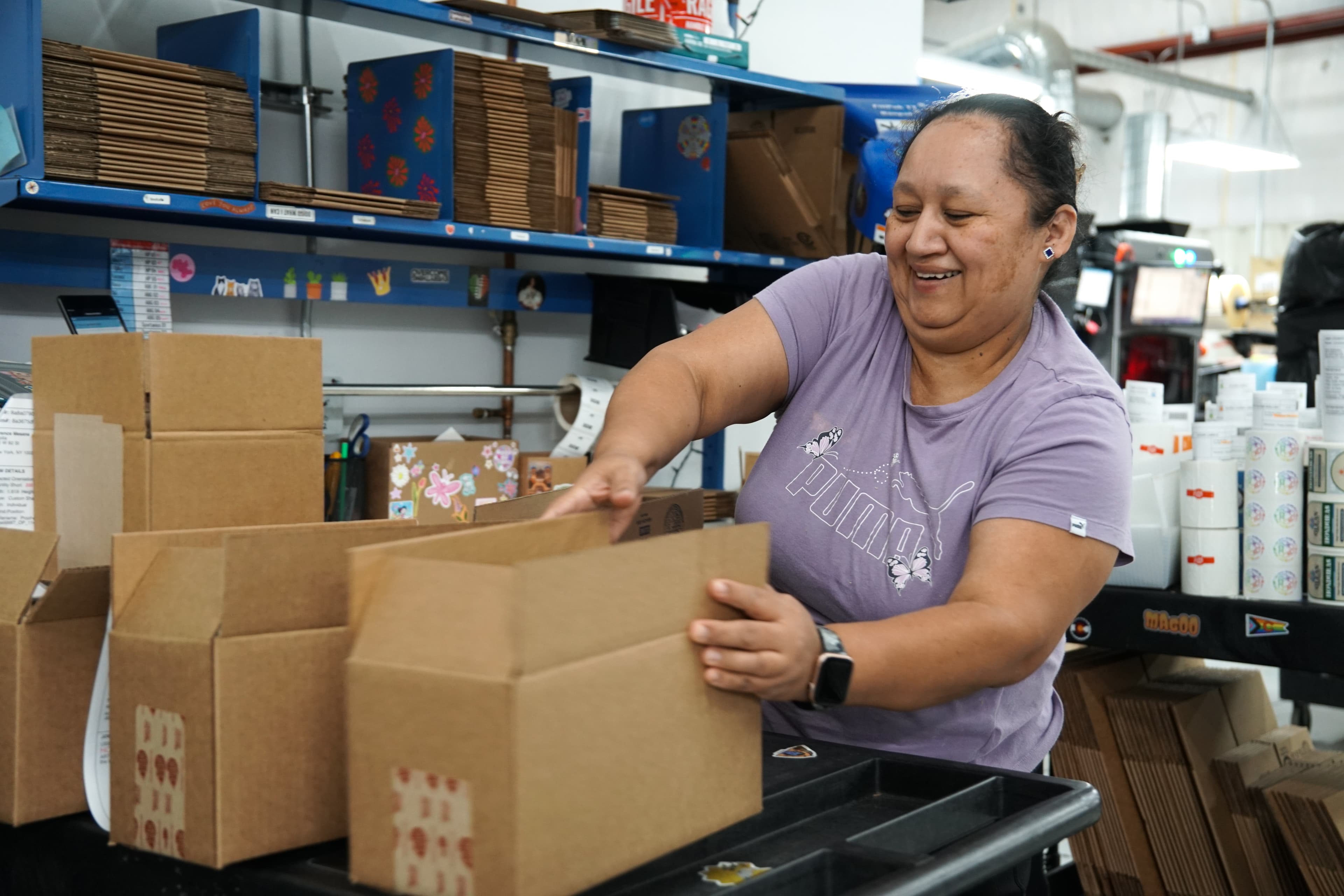 Employee packing customer orders in StickerGiant's production facility for fast turnaround and nationwide shipping.