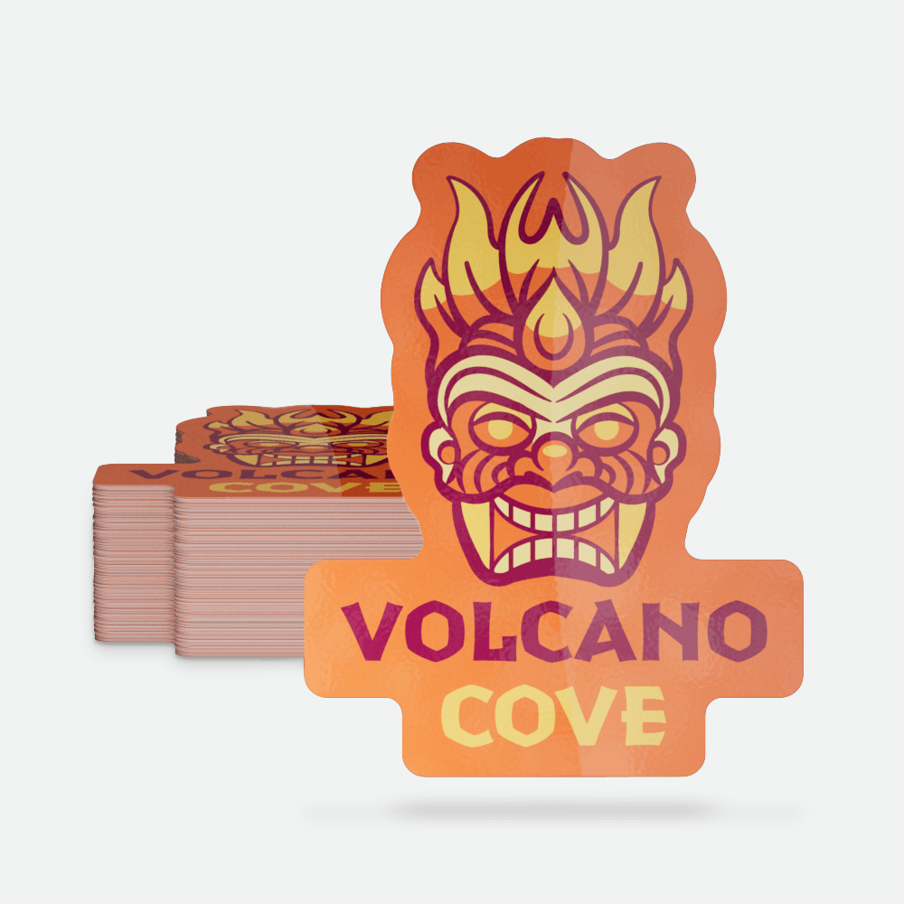A die-cut “Volcano Cove” sticker with an orange tiki mask design appears in front of a stack of matching stickers on a light gray background.