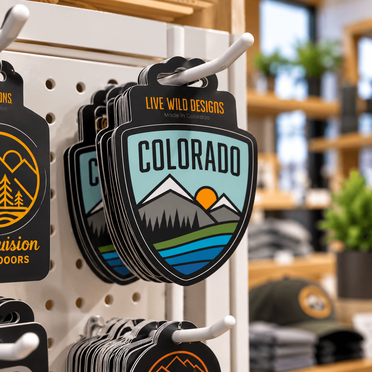 Colorado hang tag stickers displayed on a pegboard in a retail shop.