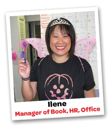 Ilene-from-StickerGiant-in-front-of-the-company-SOR-Board-with-fairy-wings-and-a-pen-wand-for-Halloween