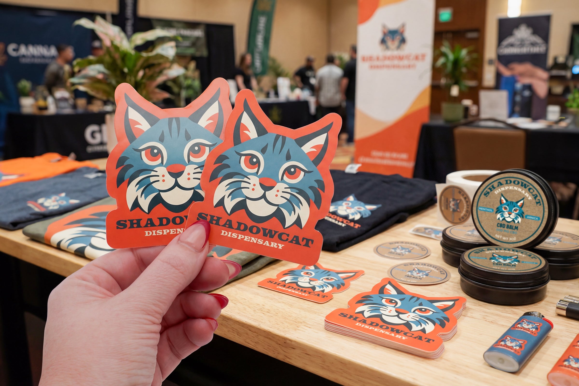 Cannabis brand stickers displayed at a trade show booth.