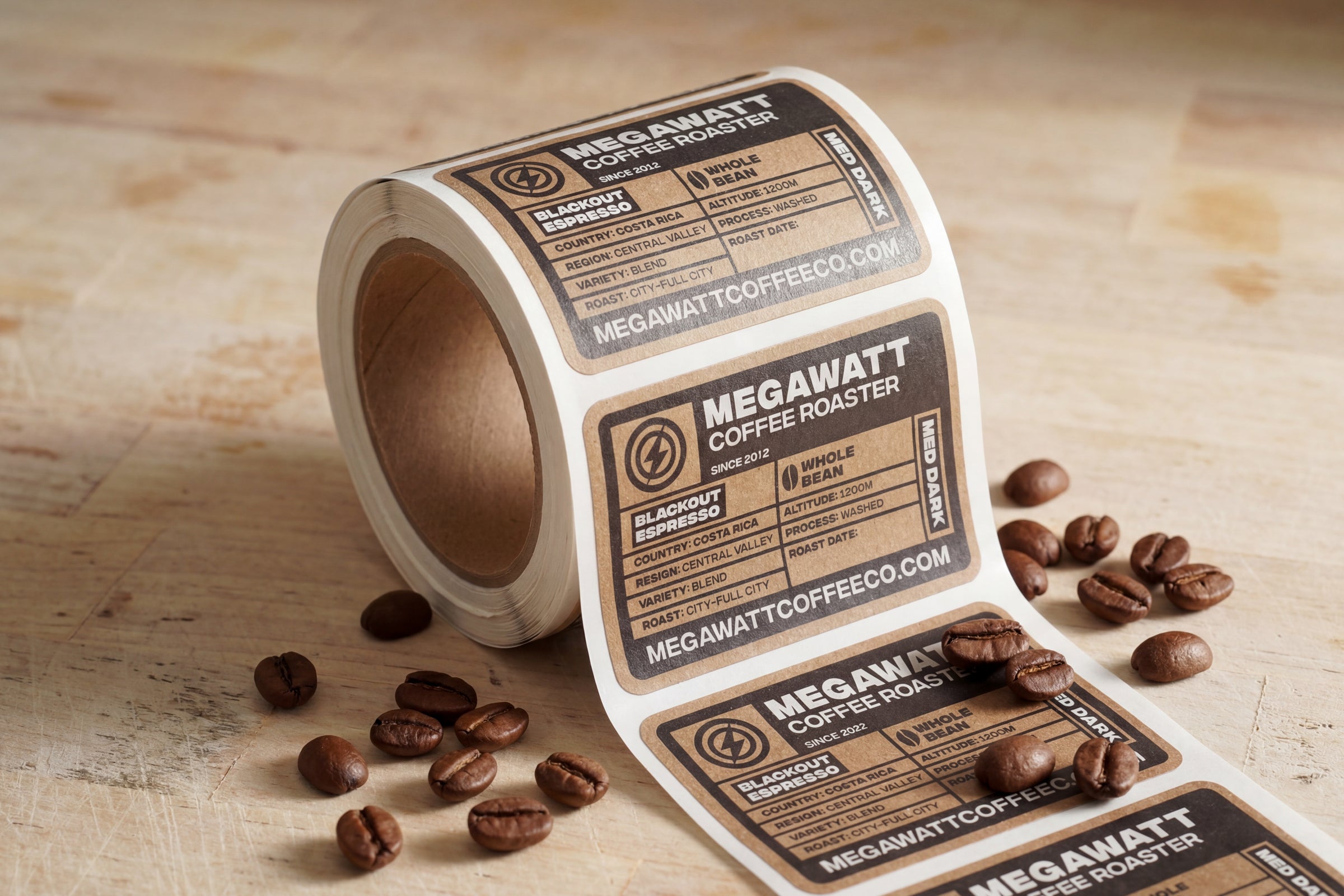 Roll of coffee bag product labels with kraft-style design and coffee beans on table.