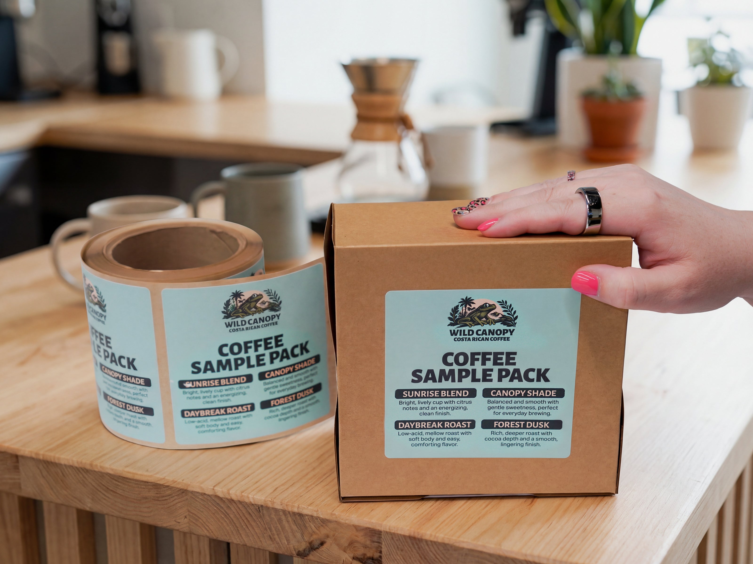 Coffee sample pack box with custom product label and label roll for coffee packaging.