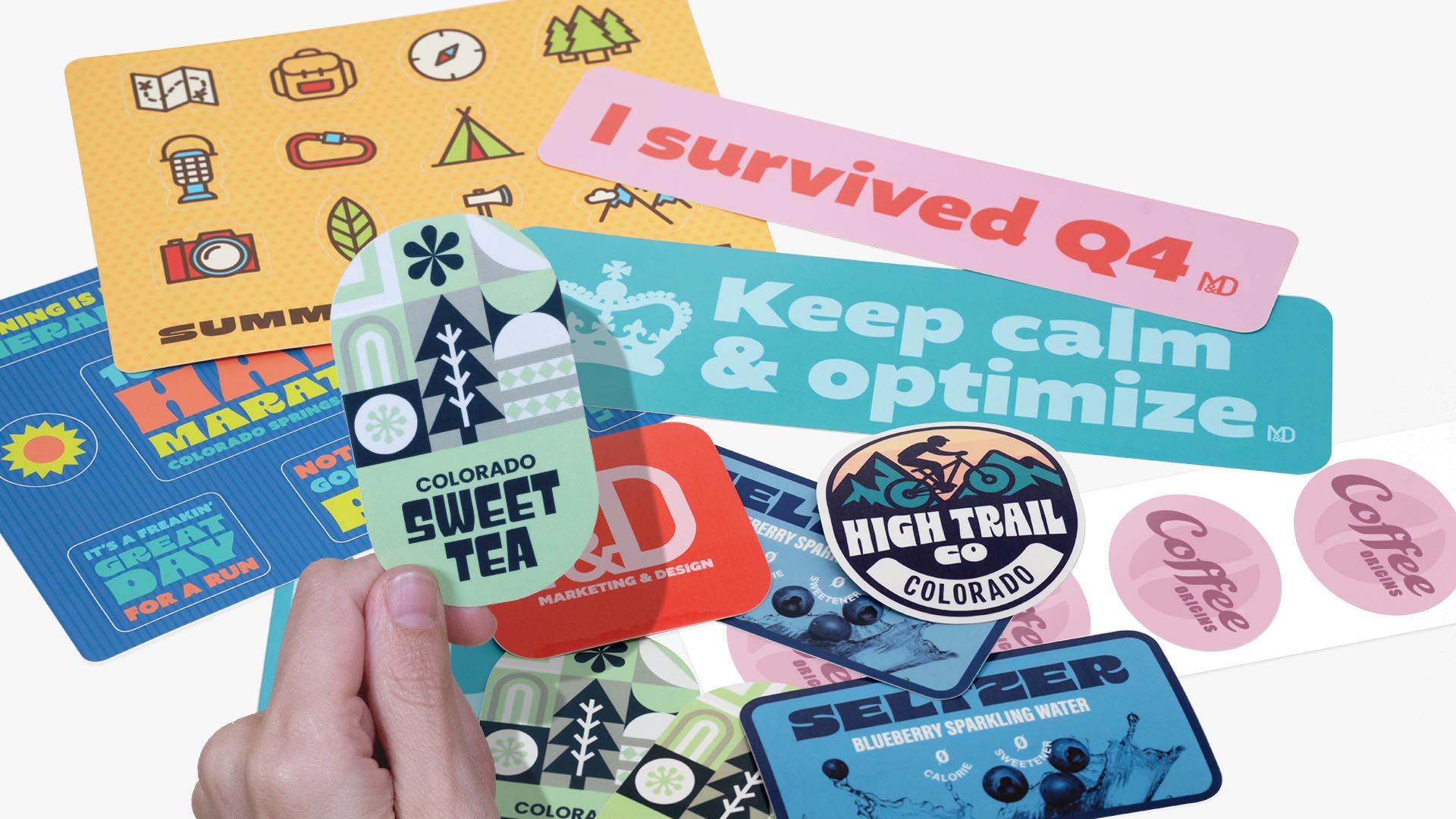 A variety of colorful custom stickers including die cut shapes, sticker sheets, and product labels featuring designs for drinks, events, and businesses.