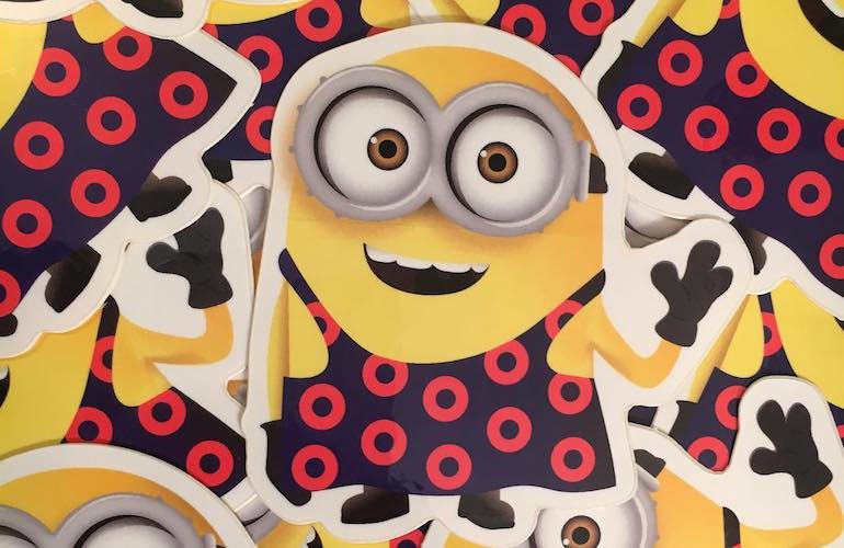A group of custom die-cut stickers featuring a cartoon yellow character with goggles wearing a dark blue outfit patterned with bright red donut-shaped circles.