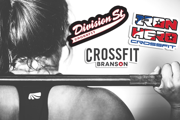 CrossFit athlete lifting a barbell with three custom gym logo stickers displayed: Division St CrossFit, Iron Hero CrossFit, and CrossFit Branson.