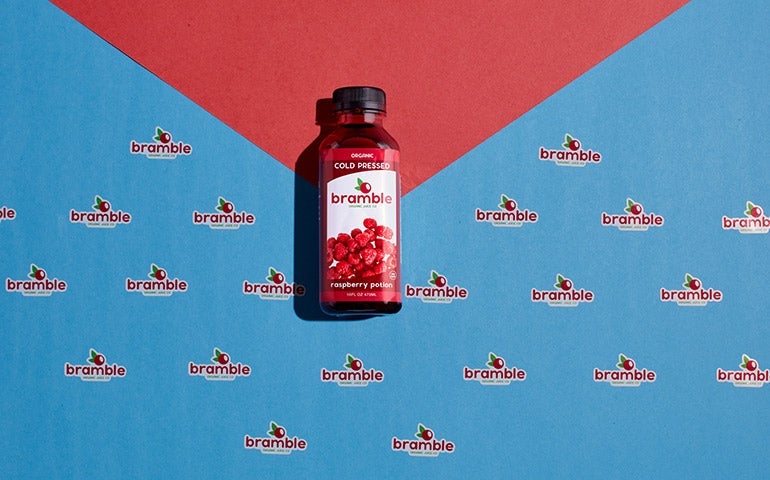 Bramble juice bottle on a patterned background with repeating Bramble logo stickers.