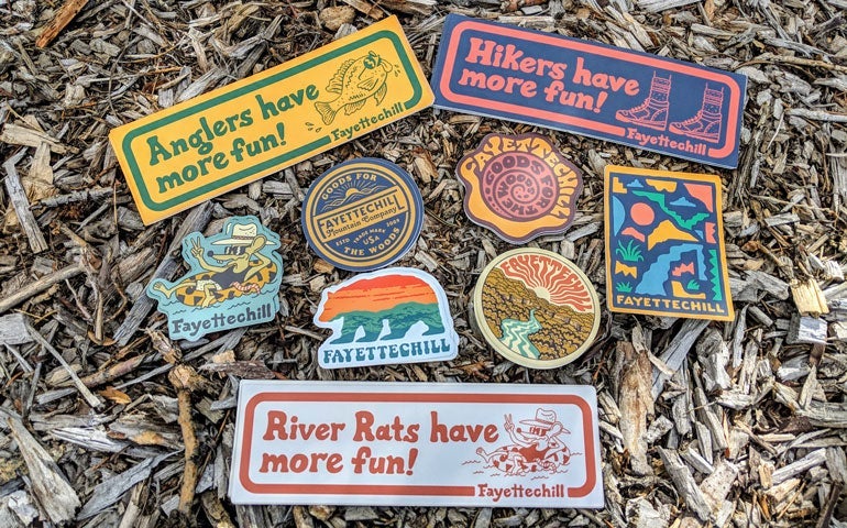 Assorted Fayettechill die cut stickers on wood mulch.