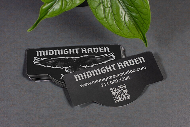 Backprinting on Midnight Raven Tattoo stickers with raven front and QR/contact info back.