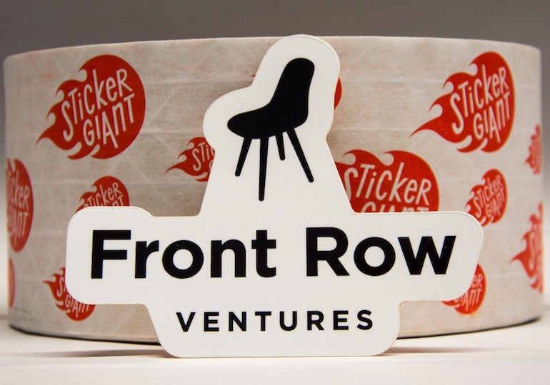Custom Front Row Ventures sticker displayed in front of a roll of StickerGiant logo stickers.