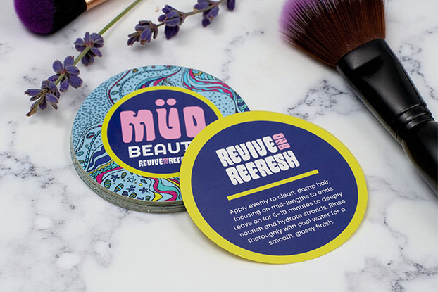 Round backprinted sticker with MüD Beauty logo and haircare instructions.