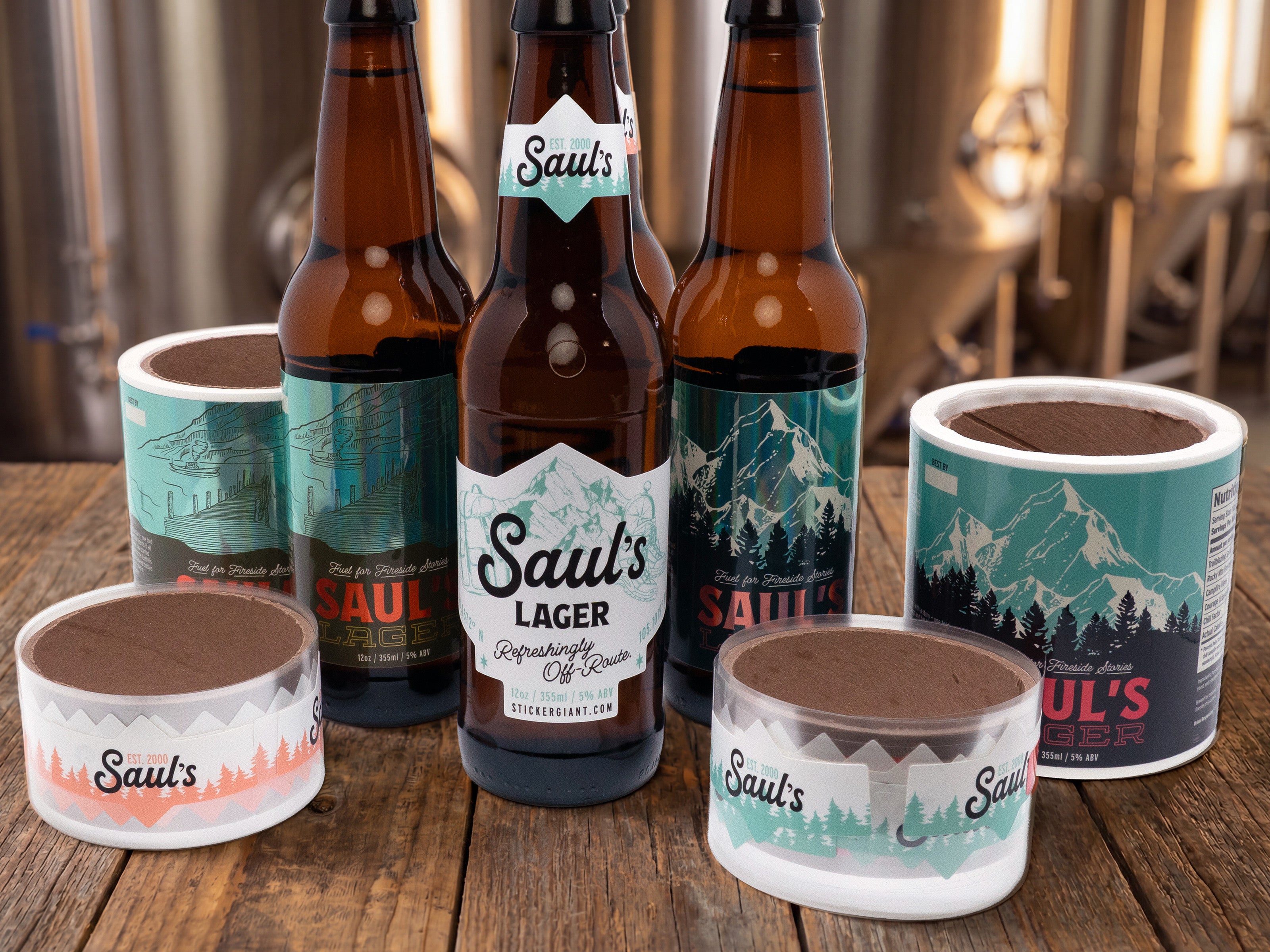 Holographic and clear brewery logo stickers held in hands for promotional branding.