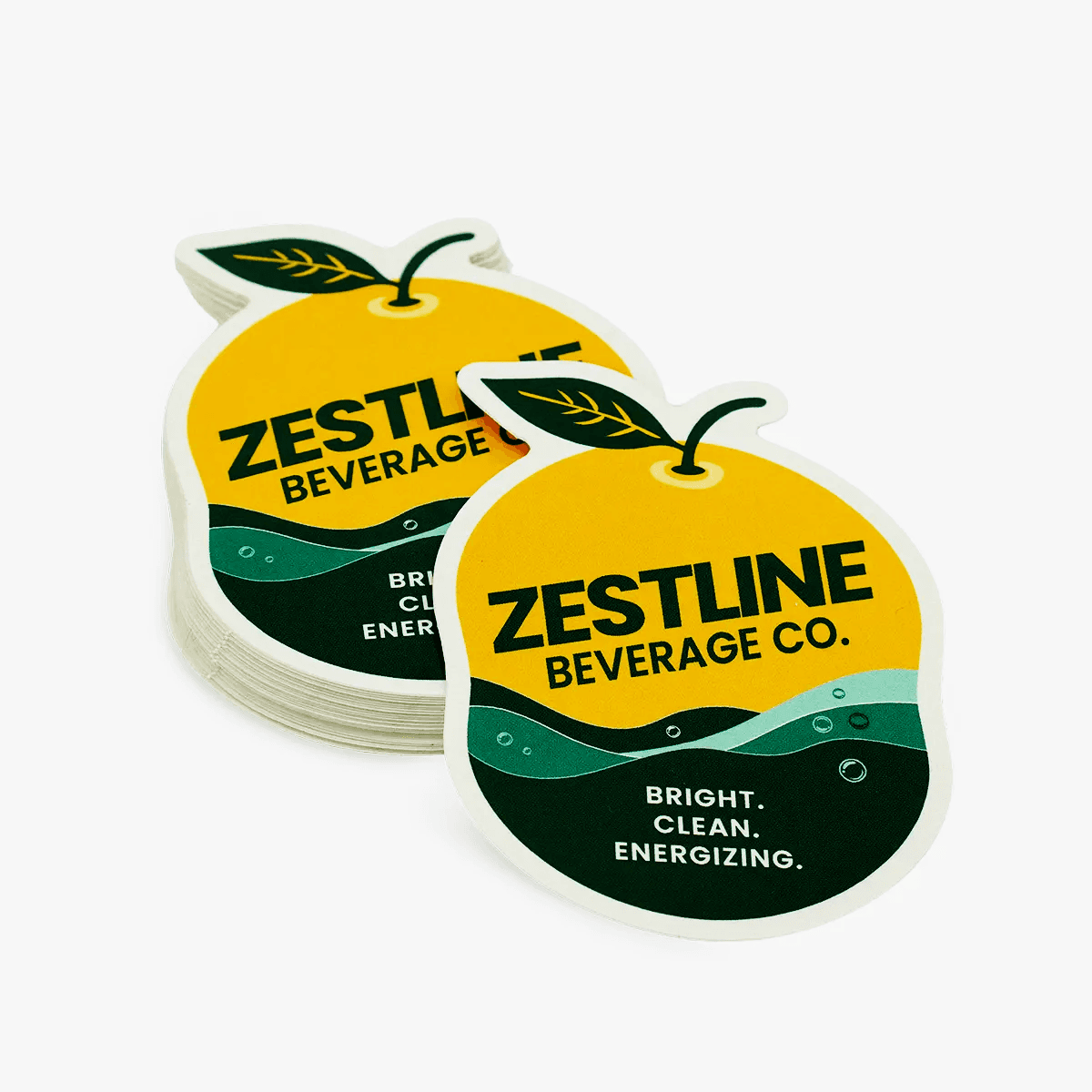 Stack of custom die cut beverage stickers shaped like lemons with colorful drink branding.